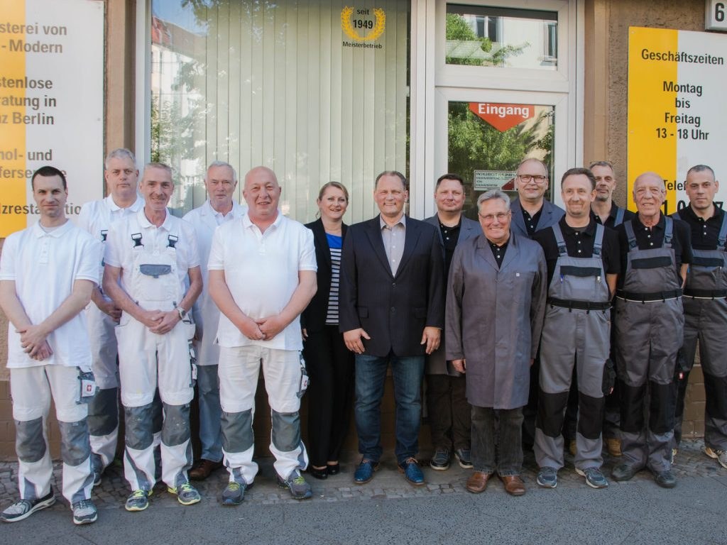 Das Team von Raumausstattung Staeck & Burneleit vor dem Geschäft in der Boxhagener Straße